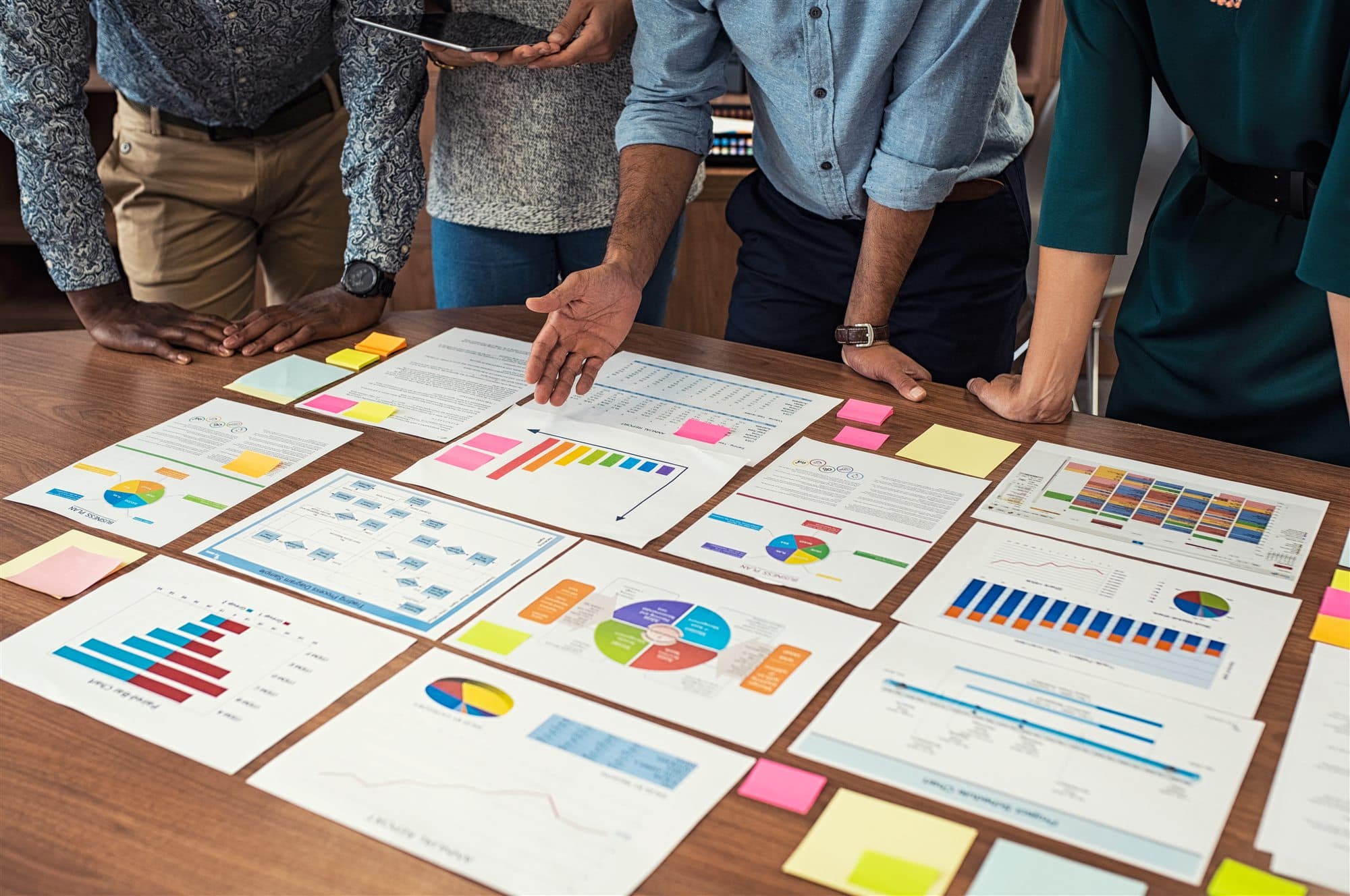 Cross-functional team analyzing process maps and performance charts